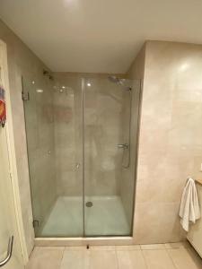 y baño con ducha y puerta de cristal. en Pis Cala Tere en Cadaqués