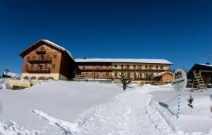 un gran edificio con nieve delante en Hotel und Landgasthof Altwirt, en Großhartpenning