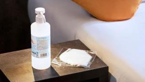 a bottle of lotion sitting on a table next to a bed at Hôtel du Plat d'Etain in Paris