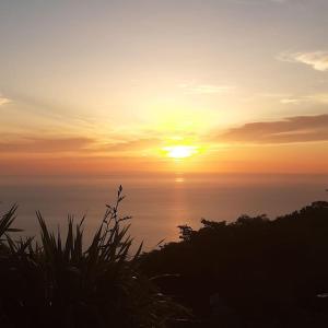 a sunset over the ocean with the sun in the sky at Panorama Villas in Drymon