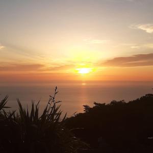 un tramonto sull'oceano con il sole nel cielo di Panorama Villas a Drymon