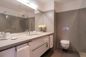 een badkamer met een wastafel, een toilet en een spiegel bij Monumental Apartment in Funchal +55 foto's