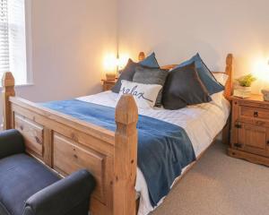 um quarto com uma cama de madeira e uma cadeira em Captains Cottage em Scarborough