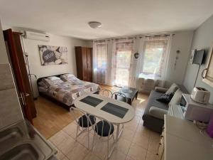 a living room with a bed and a table at Hellasz Apartman in Gyula