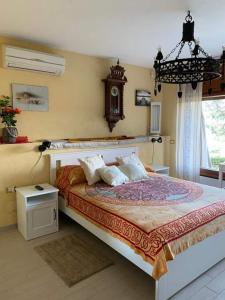 Lakshmi House في رابالو: غرفة نوم بسرير كبير وساعة على الحائط