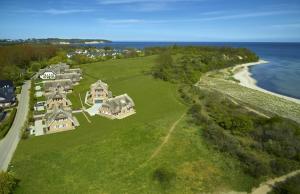 an aerial view of a house and the ocean at Strandhaus 6 "Düne" in Lobbe mit Meerblick, Kamin, Sauna in Lobbe