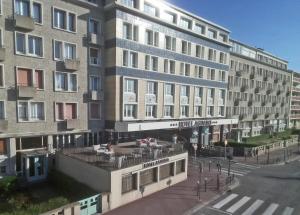 un grand bâtiment avec une rue en face dans l'établissement Hotel Aguado, à Dieppe