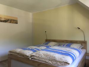 a bed with blue and white pillows on it at Weinhaus Lenartz-Bleser in Briedern
