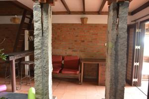 sala de estar con pared de ladrillo y sofá en Annapara Home Stay en Vythiri
