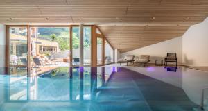 a house with a swimming pool with a wooden ceiling at Hotel Stäfeli in Lech am Arlberg