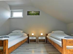 Levél的住宿－Korona Panzió，两张床位于带两盏灯的墙上。