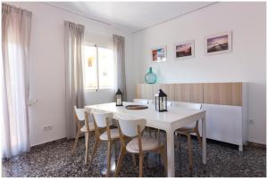 een witte eetkamer met een witte tafel en stoelen bij Apartamento en centro de Moraira in Moraira