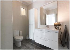 a white bathroom with a toilet and a mirror at Apartamento en centro de Moraira in Moraira +13 photos