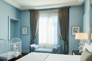 パリにあるプリンスドガル ア ラグジュアリーコレクションホテル パリの青いベッドルーム(ベビーベッド2台、窓付)