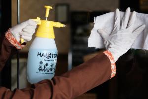 a person wearing gloves holding a bottle of bleach at Silom Space Hostel in Bangkok +37 photos
