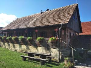 ein Gebäude mit einer Bank davor in der Unterkunft Tourist Farm Pri Martinovih in Krška Vas
