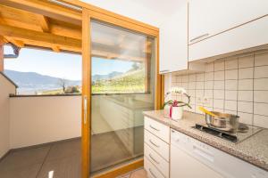 een keuken met een groot raam en een aanrecht bij Finkenhof: Ferienwohungen - Urlaub auf dem Bauernhof in Termeno