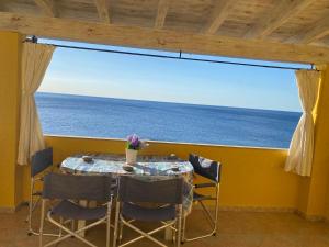 カーラゴノネにあるLa Casa Giallaの大きな窓のある客室で、テーブルと椅子が備わります。