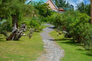 kamienna ścieżka przez ogród z drzewami w obiekcie La Belle Rodriguaise w mieście Rodrigues Island