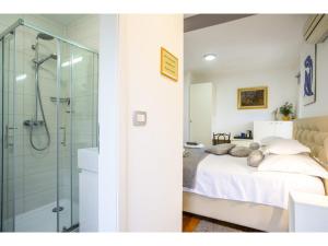 a bedroom with a bed and a glass shower at Palace Tower View in Split