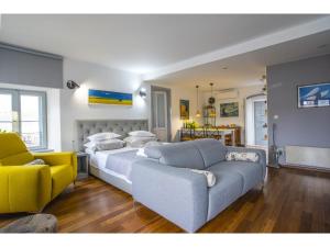 a bedroom with a large bed and a yellow couch at Palace Tower View in Split