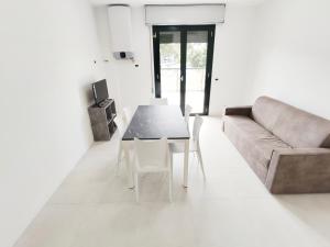 een woonkamer met een bank en een tafel bij QUITO - Appena Ristrutturato - Dietro Piazza Mazzini - Immbil Relax in Lido di Jesolo