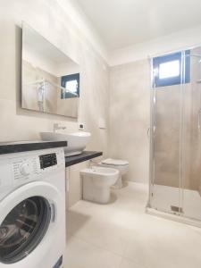Un baño con lavadora y un inodoro. en QUITO - Dietro Piazza Mazzini - Immobil Relax, en Lido di Jesolo
