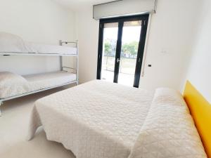 Un dormitorio con dos literas y una ventana. en QUITO - Dietro Piazza Mazzini - Immobil Relax, en Lido di Jesolo