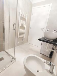 Un baño blanco con lavabo y ducha. en QUITO - Dietro Piazza Mazzini - Immobil Relax, en Lido di Jesolo 14 fotos más