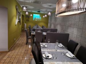 un restaurant avec des tables et des chaises et un mur vert dans l'établissement Cal Duran, à Esparraguera