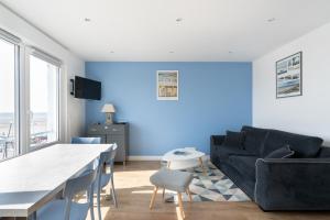 - un salon avec un canapé et un mur bleu dans l'établissement "Les Mouettes", à Boulogne-sur-Mer