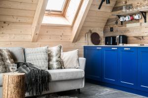 salon z niebieskimi szafkami i kanapą w obiekcie udanypobyt Domki North & South Cabin w mieście Kościelisko