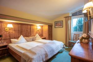 a hotel room with a large bed and a window at Harmony Hotel Sonnschein in Niederau