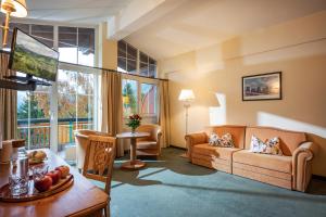 a living room with a couch and a table at Harmony Hotel Sonnschein in Niederau