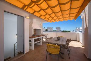a patio with a wooden table and chairs on a balcony at Villas Dulcinea in Alcossebre