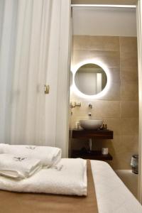 een badkamer met een wastafel, een bed en een spiegel bij Les 3 Chambres in Lecce