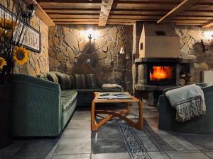 a living room with a couch and a fireplace at Penzion pod Brehom in Terchová +52 photos