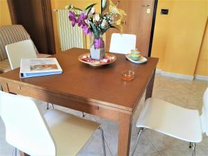 a wooden table with a vase of flowers on it at La Bomboniera in Bari