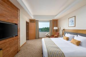 um quarto de hotel com uma cama e uma TV de tela plana em Sedona Hotel Yangon em Yangon