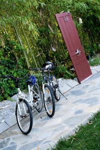 dos bicicletas estacionadas junto a una puerta roja en Sinanis Garden House, en Volos