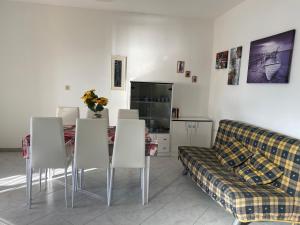 a living room with a couch and a table and chairs at La Casa Gialla in Cala Gonone