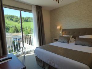 a hotel room with a bed and a large window at Urban Style L'Etape in Saint-Flour