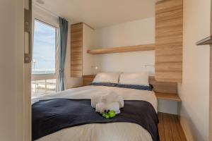朱利亚诺瓦AQUA RESORT GIULIANOVA - Houseboat Experience的一间卧室，床上有一只毛绒玩具