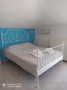 a bedroom with a bed with a blue wall at Olympus and Sea View Apartments in Néa Michanióna