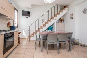 a kitchen with a table and chairs and a staircase at Villa Pietro in Lascari