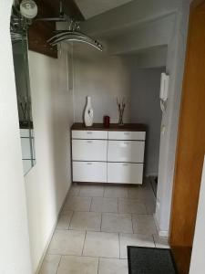 uma cozinha com armários brancos e piso em azulejo em Zur alten Post em Pirna