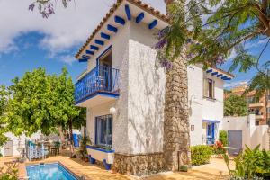 a villa with a swimming pool and a tree at Blue Castle GuestHouse in Málaga