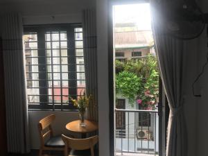 a room with a table and a view of a balcony at Jasmine Mini Hotel in Hue