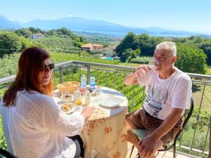 een man en vrouw die aan een tafel wijn drinken bij Antiche Mura Casa Vacanze in Puegnago