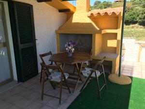 a table and chairs on a patio with a fireplace at Casa di Campagna in Gallura in Luogosanto